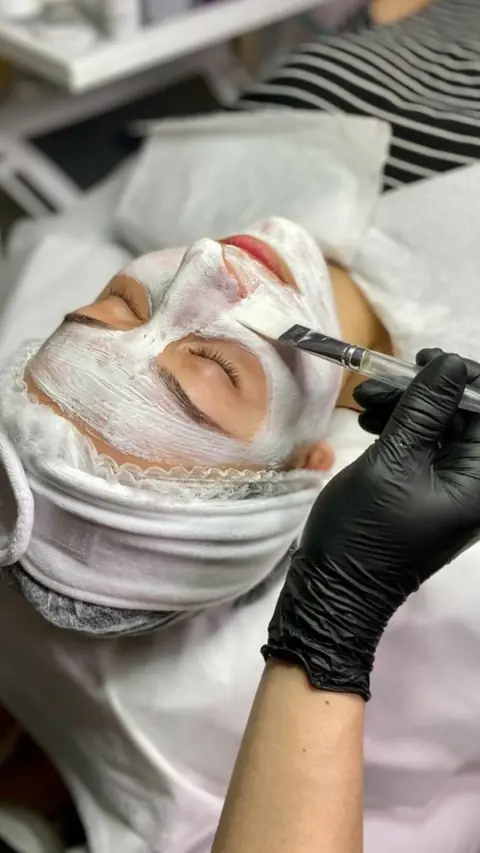 Cliente recebendo limpeza de pele com máscara facial