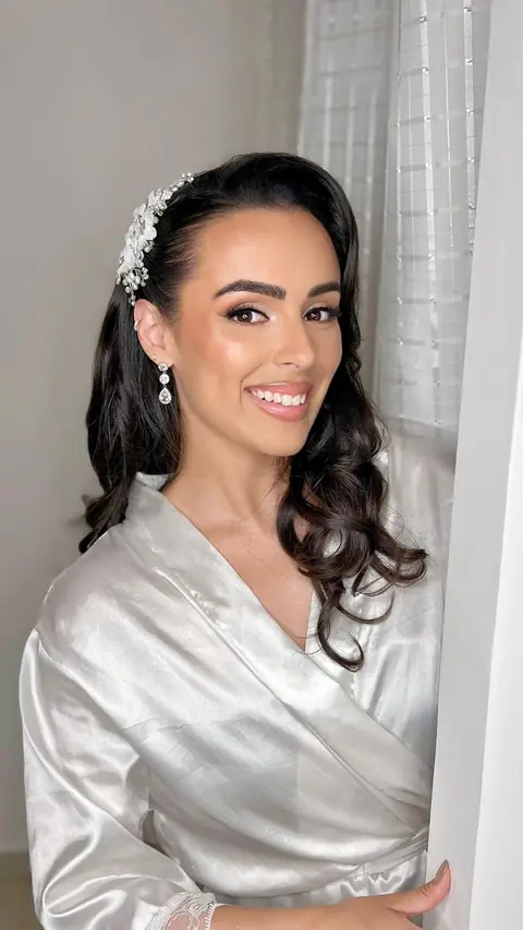 Cliente com maquiagem profissional para noiva e acessório de cabelo