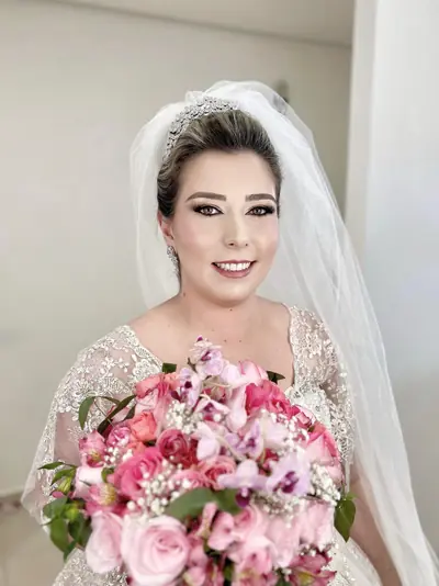 Ariana vestida de noiva com véu e buquê de rosas
