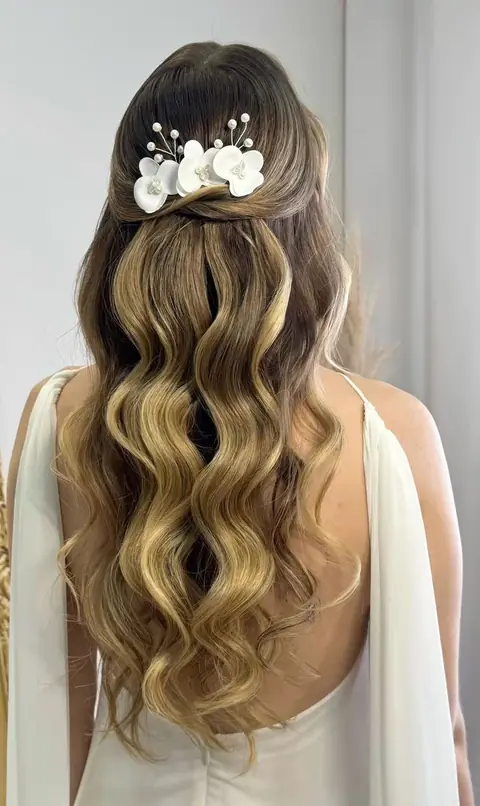 Penteado semipreso com ondas longas e flores no cabelo